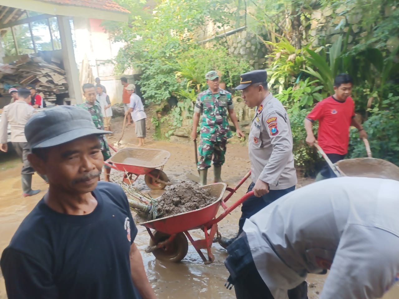 Sejumlah personel TNI-Polri bersama petugas dari Kecamatan dan warga bergotong royong membersihkan material tanah longsor yang menimpa bangunan SDN 2 Surenlor, Kecamatan Bendungan, Kabupaten Trenggalek. Selasa, (27/2).