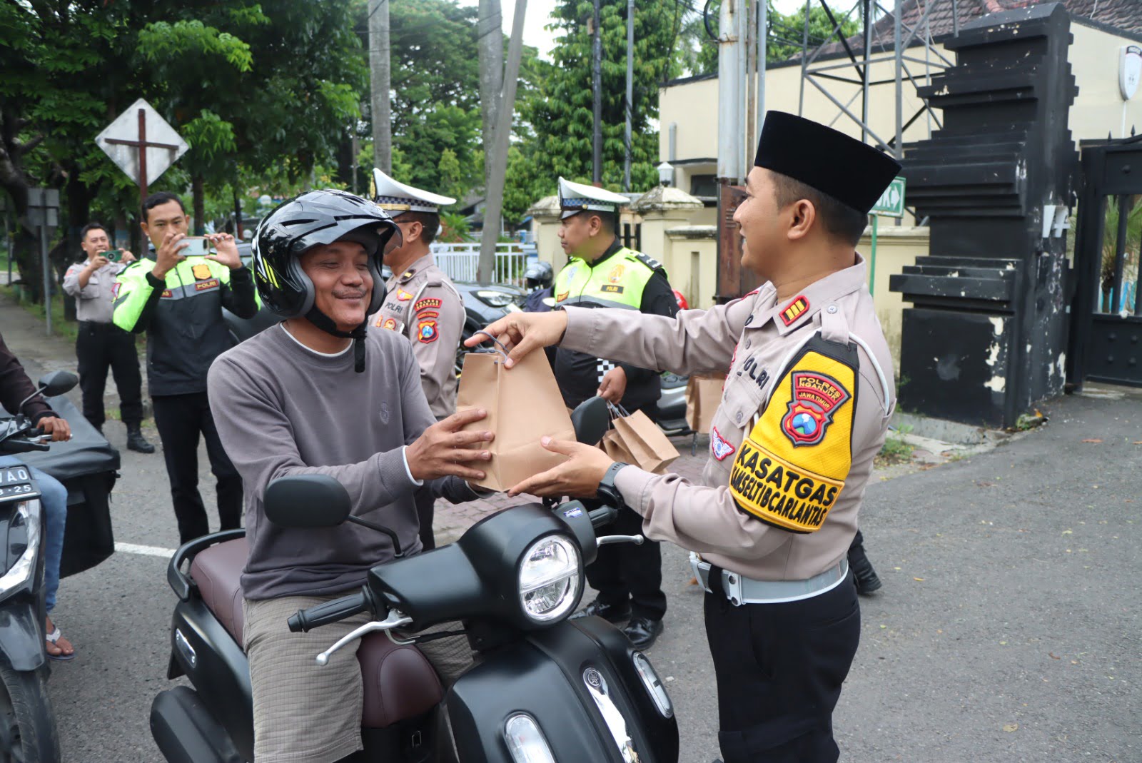 Kapolres AKBP Muhammad, S.H., S.I.K., M.Si., didampingi Pejabat Utama (PJU) dan puluhan anggotanya membagikan bingkisan takjil pada hari pertama puasa kepada pengguna jalan yang kebetulan melewati depan mako Polres Nganjuk, Senin (12/03/2024). 