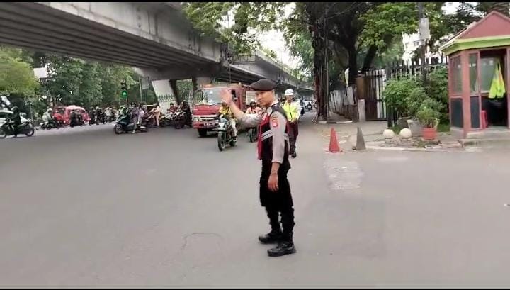 Personel Samapta Polres Metro Jakarta Barat melaksanakan pengaturan arus lalu lintas saat jam berangkat kerja masyarakat, Rabu, 24/4/2024. 